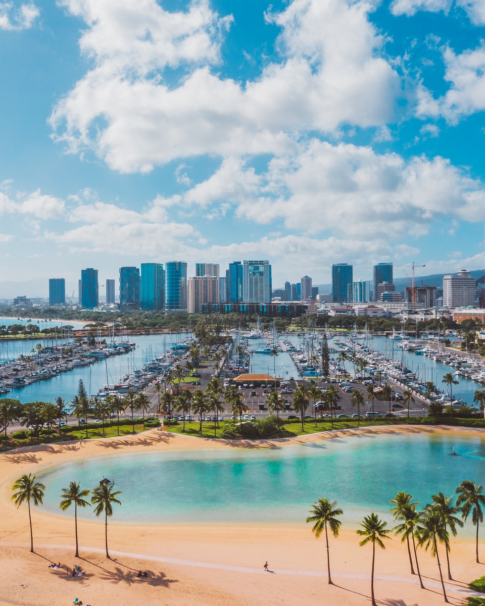 Photo by Jess Loiterton Aerial View of City Buildings Near Body of Water